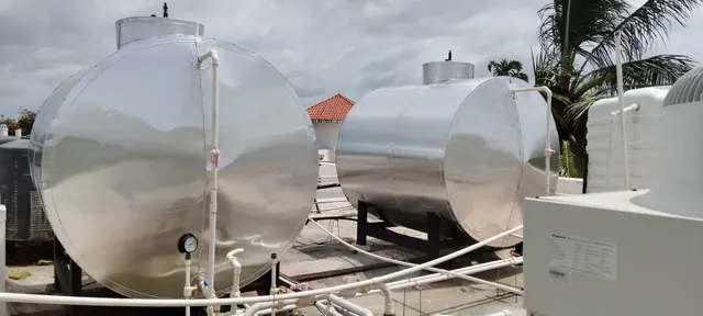 Two insulated hot water tanks with heat pump units on a rooftop