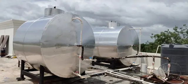 Two insulated hot water tanks on steel stands on a terrace