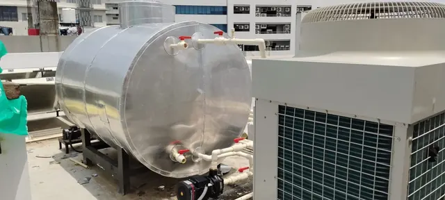 Insulated hot water tank with a large heat pump on a commercial rooftop