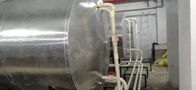 Insulated hot water tank and pipework in a basement plant room