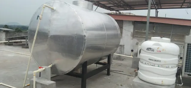 Insulated hot water tank beside a cold water tank on a rooftop